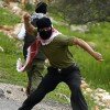 Arab using sling to throw rocks at IDF